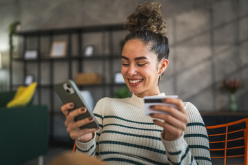 young woman caucasian female hold credit card online shopping at home