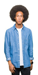 Young african american man with afro hair puffing cheeks with funny face. Mouth inflated with air, crazy expression.