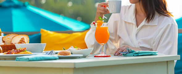 Woman drinking coffee and orange juice on the dining tableBuffet service. Tasty breakfast served on...