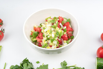 Salad of chopped tomatoes with green onions and peppers with cucumbers.