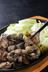 柚子胡椒をつけて地鶏を食べる