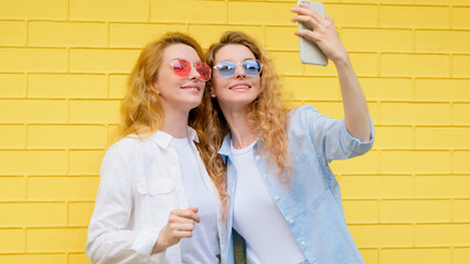 Selfie, friends, and woman posing with phone outside, peace sign for social media post. Two women...