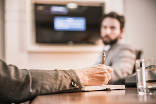 Two colleagues having a teams meeting in a conference room with third colleague