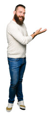 Young hipster man wearing winter sweater Pointing to the side with hand and open palm, presenting ad smiling happy and confident