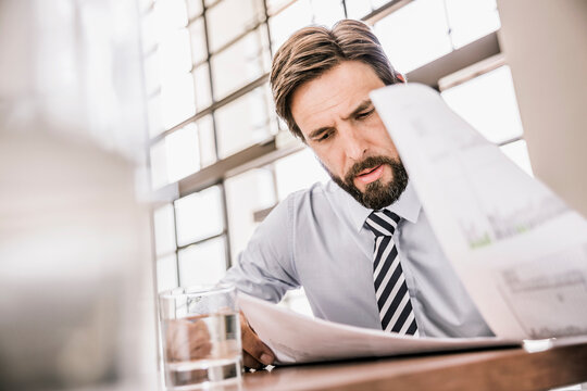 Portrait of businessman going through some paper work in the office