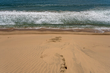 dune slope and Atlantic waves from above at Sandwich Harbour, Namibia