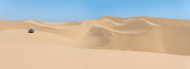 tourists and 4x4 at dunes on shore of Naukluft desert, Walvis Bay, Namibia
