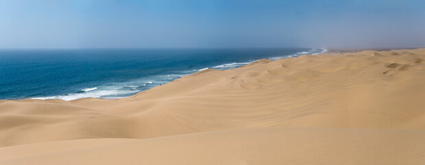 Fototapeta na wymiar tourists at dunes on shore of Naukluft desert, Walvis Bay, Namibia