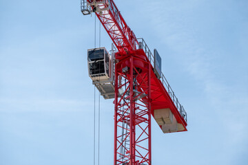 Detail of red tower crane with telescopic arm, stairs and cabin for workers, Netherlands