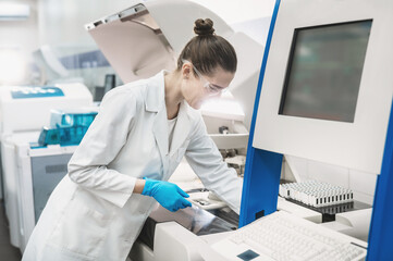 female scientist working in a modern equipped computer laboratory analyzes blood samples and genetic materials using special machines in a modern laboratory.