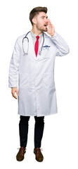Fototapeta premium Young handsome doctor man wearing medical coat shouting and screaming loud to side with hand on mouth. Communication concept.