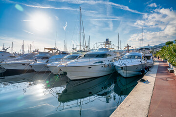 Fototapeta premium Sanremo, Italy - December 30, 2023: Yachts along the port of Sanremo on a beautiful afternoon
