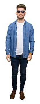 Young handsome elegant man wearing denim jacket with a happy and cool smile on face. Lucky person.