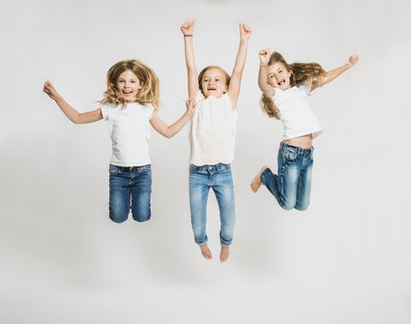 Portrait of three young girls in studio with white background.