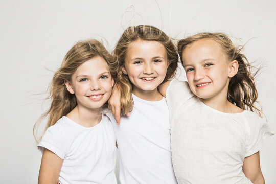 Portrait of three young girls in studio with white background.