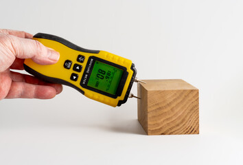 man holding a moisture meter for measuring the Relative humdity of a piece of oak wood