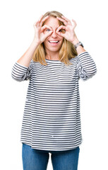 Beautiful young woman wearing stripes sweater over isolated background doing ok gesture like binoculars sticking tongue out, eyes looking through fingers. Crazy expression.