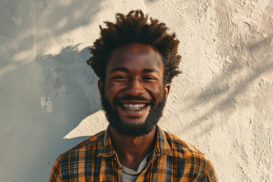 Close up portrait of a happy young african american man smiling against white wall.