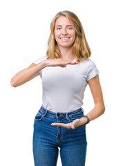 Fototapeta premium Beautiful young woman wearing casual white t-shirt over isolated background gesturing with hands showing big and large size sign, measure symbol. Smiling looking at the camera. Measuring concept.