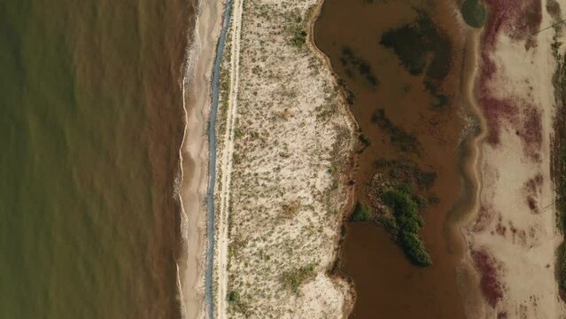 4K aerial video birds eye view with a beach between sea shore lakes and red algae layer., seaside video.