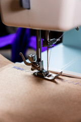 Máquina de costura, papel pardo e linha roxa