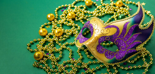 Mardi Gras Carnival Masks, Gold Beads on Green Background.