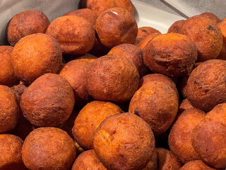 Selective focus of Oliebol in showcase display at the market, Typical food or sweet commonly known as Dutch doughnuts or dutchies, Oliebollen are traditionally eaten on New Year's Eve, Netherlands.