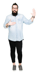 Young hipster man with long hair and beard wearing glasses Swearing with hand on chest and open...