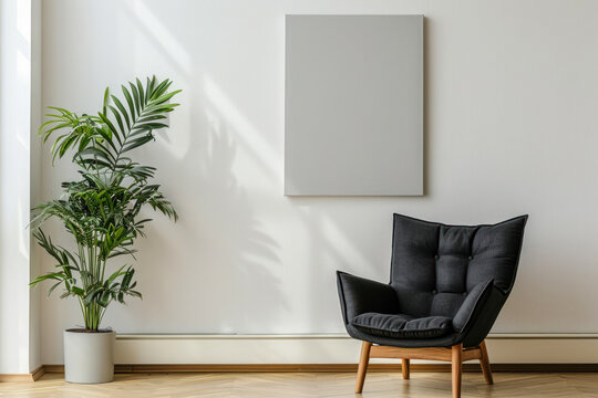 Black armchair between dandelion and plant in living room interior with copy space and grey painting.