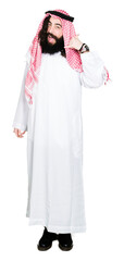 Arabian business man with long hair wearing traditional keffiyeh scarf smiling doing phone gesture with hand and fingers like talking on the telephone. Communicating concepts.