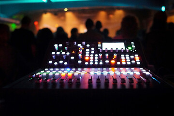 A vibrating club, suffused with neon light. At the center: a lively mixing desk