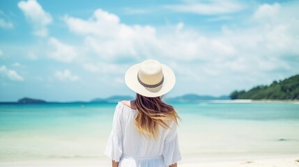 Fototapeta na wymiar Happy traveler woman in white dress and hat standing on beautiful tropical sandy beach. vacation concept.