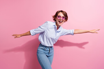 Portrait of overjoyed carefree pretty girl weekend clubbing dancing chilling isolated on pink color background