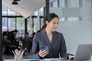 Sharing good business news. Attractive young businesswoman talking on the mobile phone and smiling...