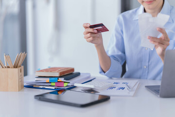 Asian businesswoman sitting in the office and be serious with her credit card bill.