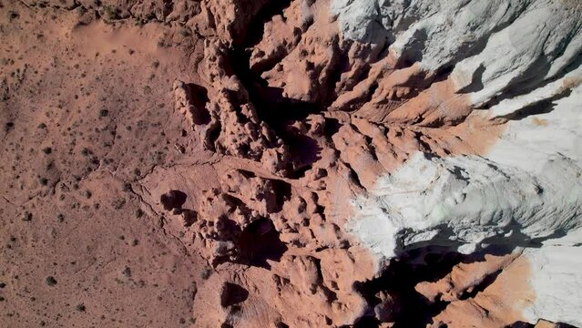 Top down aerial view to the big eroded butte and mesa mountains in red rock rocky desert. Utah, USA. Drone footage.