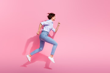 Full body profile photo of overjoyed active lady jump run fast empty space isolated on pink color...