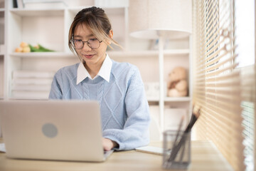 Woman typing in front of a laptop, Hand pressing laptop keyboard, Intention to work in the office.
