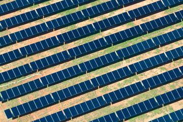 Aerial view of large sustainable electrical power plant with rows of solar photovoltaic panels for producing clean electric energy. Concept of renewable electricity with zero emission