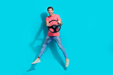 Full length photo of impressed good mood guy dressed pink polo jumping high driving car isolated...