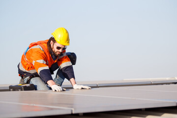 Professional electric engineers survey and inspect solar panels installation on the factory metal...