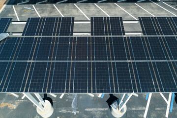 Failing of photovoltaic technology integrated in urban infrastructure. Hurricane wind damage to solar panels installed as shade roof over parking lot for parked electric cars