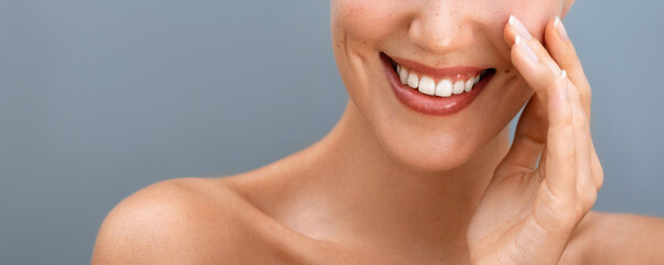 Oral care treatments. Tooth cleansing and hygiene. Cropped close up beauty portrait of a young woman is touching her face and smiling.