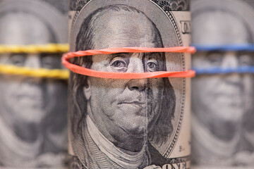 One hundred dollar bills with a close-up portrait of President Franklin. Rolls with elastic band.