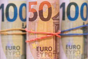 Fifty and one hundred euro bills in rolls.