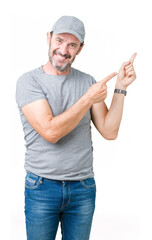 Handsome middle age hoary senior man wearing sport cap over isolated background smiling and looking at the camera pointing with two hands and fingers to the side.