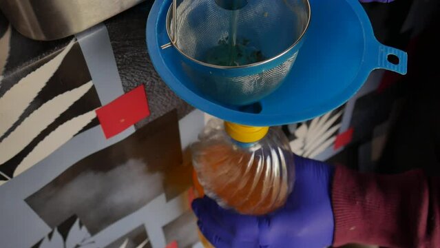used frying oil. separation of oil from the fryer after being used. with funnel, plastic bottle and filter to retain food impurities