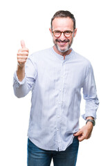 Fototapeta premium Middle age hoary senior man wearing glasses over isolated background doing happy thumbs up gesture with hand. Approving expression looking at the camera with showing success.