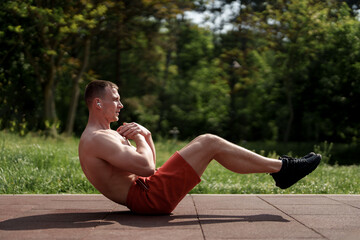 Focused man engaged in an abdominal workout in a serene park setting, emphasizing core strength