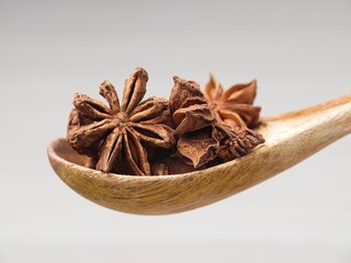 Side view of dried star anise on a spoon.